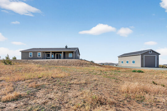 Main House Paired With Utility Outbuilding And Open Land Creating Flexible Property Layout