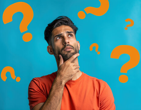 Man pondering with question marks on a vibrant blue background during a thoughtful moment