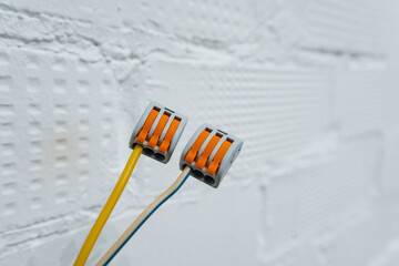 electric connection on plaster wall, closeup of electrical wiring in renovation context, detailed view showing electrical connection setup on plaster background for construction projects