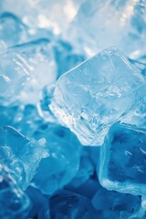 Close up of ice cubes against blue background, clear frozen water crystals with refreshing cool atmosphere and detailed texture.