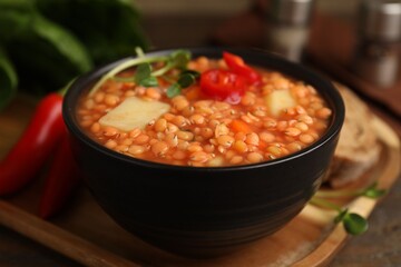 Delicious lentil soup with vegetables served on table, closeup