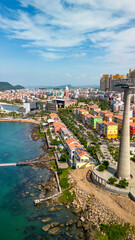 Fototapeta premium Aerial view of Sunset Town in Phu Quoc with colorful buildings, the coastal cable car, and the Kiss Bridge. Scenic tropical waterfront and vibrant seaside architecture in Vietnam.
