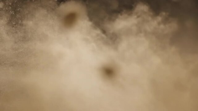 Exploding debris and dust cloud against black background