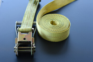 Close-up of ratchet tie-down strap and rolled cargo strap

