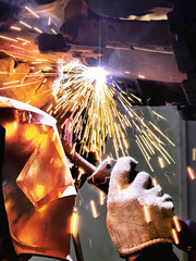A welder repairs a car's exhaust system, focuses on safety, and uses a burner to cut heated steel...