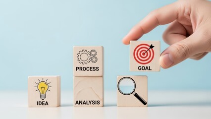 Hand placing a wooden block with a target symbol representing goal achievement in a business strategy sequence