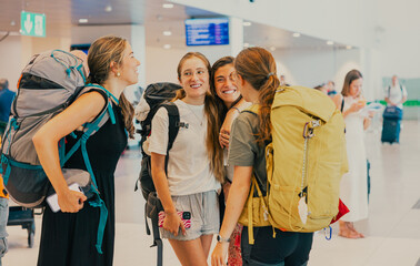 Happy women backpackers reunite in airport terminal for travelling © mariamontoyart