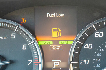 Car dashboard with fuel low warning and illuminated indicators