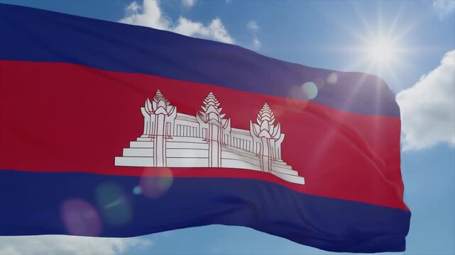 Cambodia flag with Angkor Wat temple waving in the sunlit blue sky with white clouds and lens flare national flag