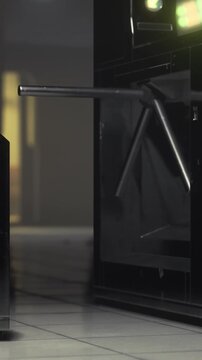Metal turnstiles stand in a dimly lit transit station, their sleek design reflecting ambient light. The atmosphere is quiet, hinting at a serene night without hustle.