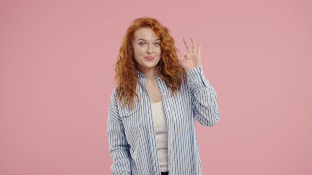 Positive smiling woman With Hand Sign Ok, Okay Gesture. Young Lady On Pink Wall