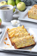 Pieces of pie with pears and apples, cup of coffee on light gray background