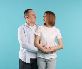 Happy couple together on light blue background