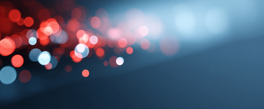 Abstract bokeh background with red and blue circular light spots on a dark gradient surface, creating a soft and blurred visual effect