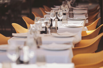 Elegant dining setup with neatly arranged tables and glassware in a modern restaurant during a bright day