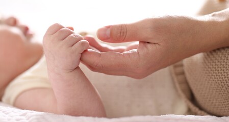 Mother with her cute newborn baby indoors, closeup