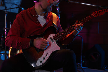 Obraz premium Man playing electric guitar on stage, closeup