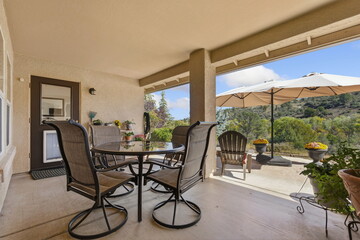 Naklejka premium Patio Umbrella For Scenic Outdoor Meals, Umbrella Over Patio Table Offering Views Of Hills And Valleys