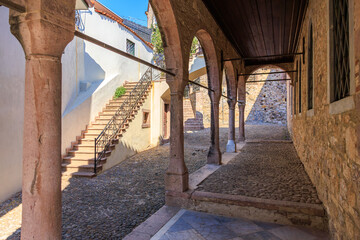 Historic stone corridor with staircase and arched columns in mediterranean village