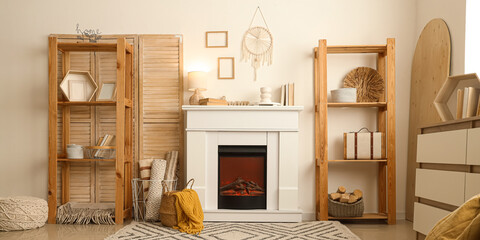 Fototapeta premium Interior of cozy living room with fireplace, shelving unit and dresser