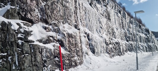 Winter scene capturing icy rock formation and snow-covered ground in a cold northern location