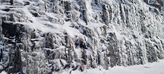 Snow-covered rocky cliff in a winter landscape captures the beauty of nature's cold season