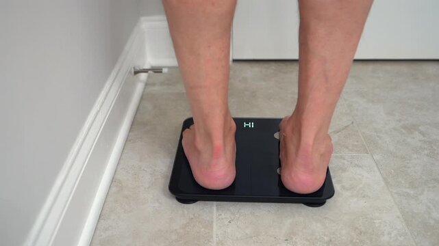 person stepping onto a smart digital bathroom scale