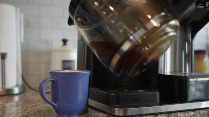 pouring hot coffee into ceramic mug