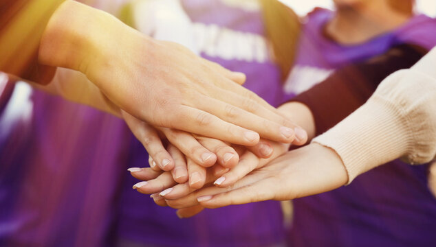Group of volunteers stacking hands outdoors on sunny day, closeup. Banner design - Powered by Adobe