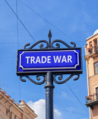 Obraz premium Trade war symbol. Concept word Trade war on beautiful blue road sign. Beautiful blue sky and buildings background. Business trade war concept. Copy space.