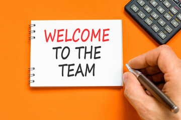 Support, help welcome to the team symbol. Concept words Welcome to the team on beautiful white note. Beautiful orange background. Businessman's hand. Business welcome to the team concept. Copy space.