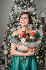 Smiling Woman Holding Festive Bouquet by Christmas Tree