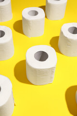 Rolls of toilet paper on yellow background