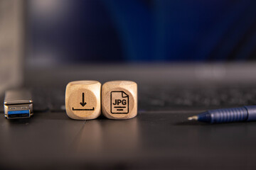The word download with arrow icon on wooden cube with computer keyboard.