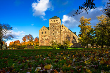 Historic Turku Castle Surrounded by Vibrant Golden Autumn Foliage in Finland.