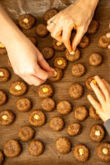 Top view of multiple hands from mother and children decorating cookies on a tray. Busy family Christmas baking scene