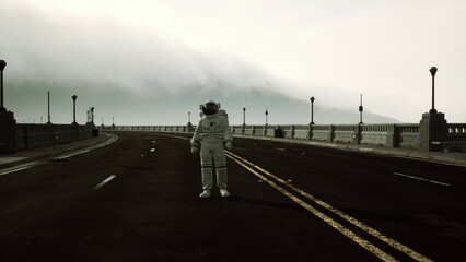 An astronaut in a white spacesuit stands solitary in the middle of a deserted road. The landscape is shrouded in mist, creating an eerie atmosphere.