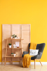 Fototapeta premium Interior of living room with wooden folding screen, shelf unit and armchair