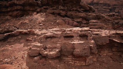 Vast sandstone formations stretch across the rugged desert, showcasing unique textures and colors under the warm sunlight. The stark beauty invites exploration and contemplation.