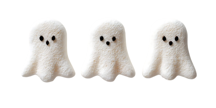 Three adorable fluffy white ghost-shaped candies with black eyes and mouths, isolated on a white background.