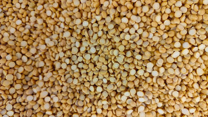 A close-up top view of raw dried dhal peas. Legume commonly used in soups, curries, and salads.