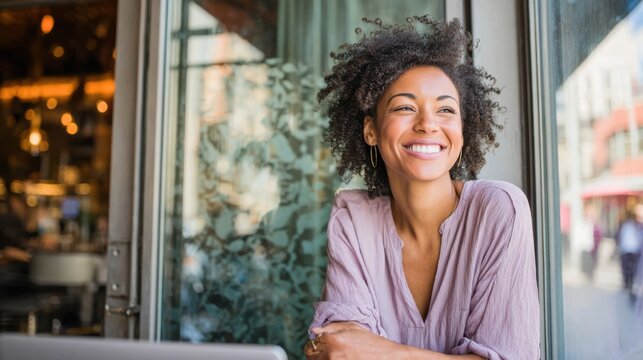Smiling woman looks out window, showing genuine happiness, relaxing inside modern urban cafe.