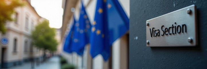 Visa Section sign on wall with European Union flags in soft focus, indicating immigration processes. Visa Section guidance for citizens and expats to complete travel process in Europe.
