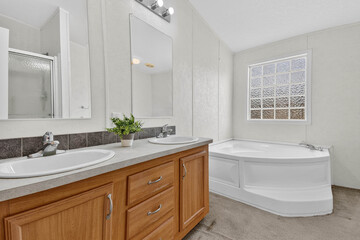 Expansive Bathroom Area Featuring Soaking Tub In Corner And Dual Vanity With Polished Granite Countertops