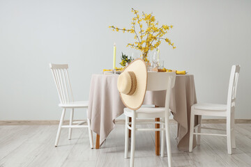 Elegant table setting with burning candles, glasses and blooming tree branches