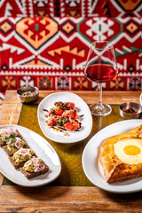 Georgian appetizers, khachapuri and wine on ethnic table