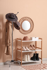Interior of hallway with stylish hats, coat rack and shelf unit