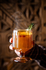Hot sea buckthorn mulled drink with rosemary garnish