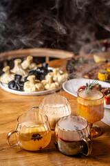 Steaming mulled drinks with khinkali and grilled dishes on table