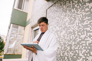 Obraz premium Focused student on balcony surrounded by urban nature environment